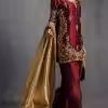 Model display: Elegant maroon handcrafted ethnic dress styled with golden dupatta for festive occasions.