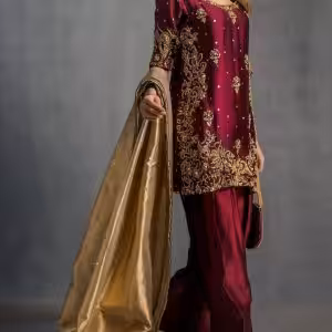 Model display: Elegant maroon handcrafted ethnic dress styled with golden dupatta for festive occasions.