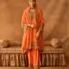 Model wearing peach gold embroidered salwar suit with matching dupatta and traditional jewelry