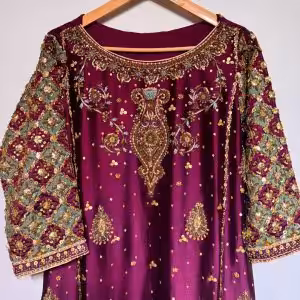 Ornate hand-embroidered lattice sleeve detail on maroon ethnic dress.