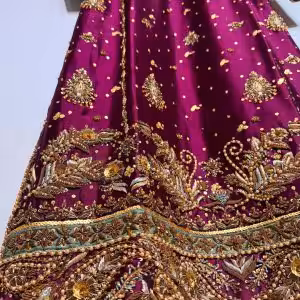 Ornate hand-embroidered lattice sleeve detail on maroon ethnic dress.