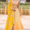 Front view of vibrant yellow organza lehenga set with intricate mirror hand embroidery by CoutureCraze